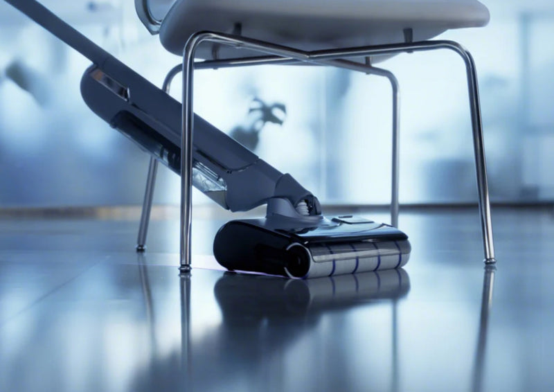 The s20 pro cordless vacuum and mop is cleaning the floor under the chair.