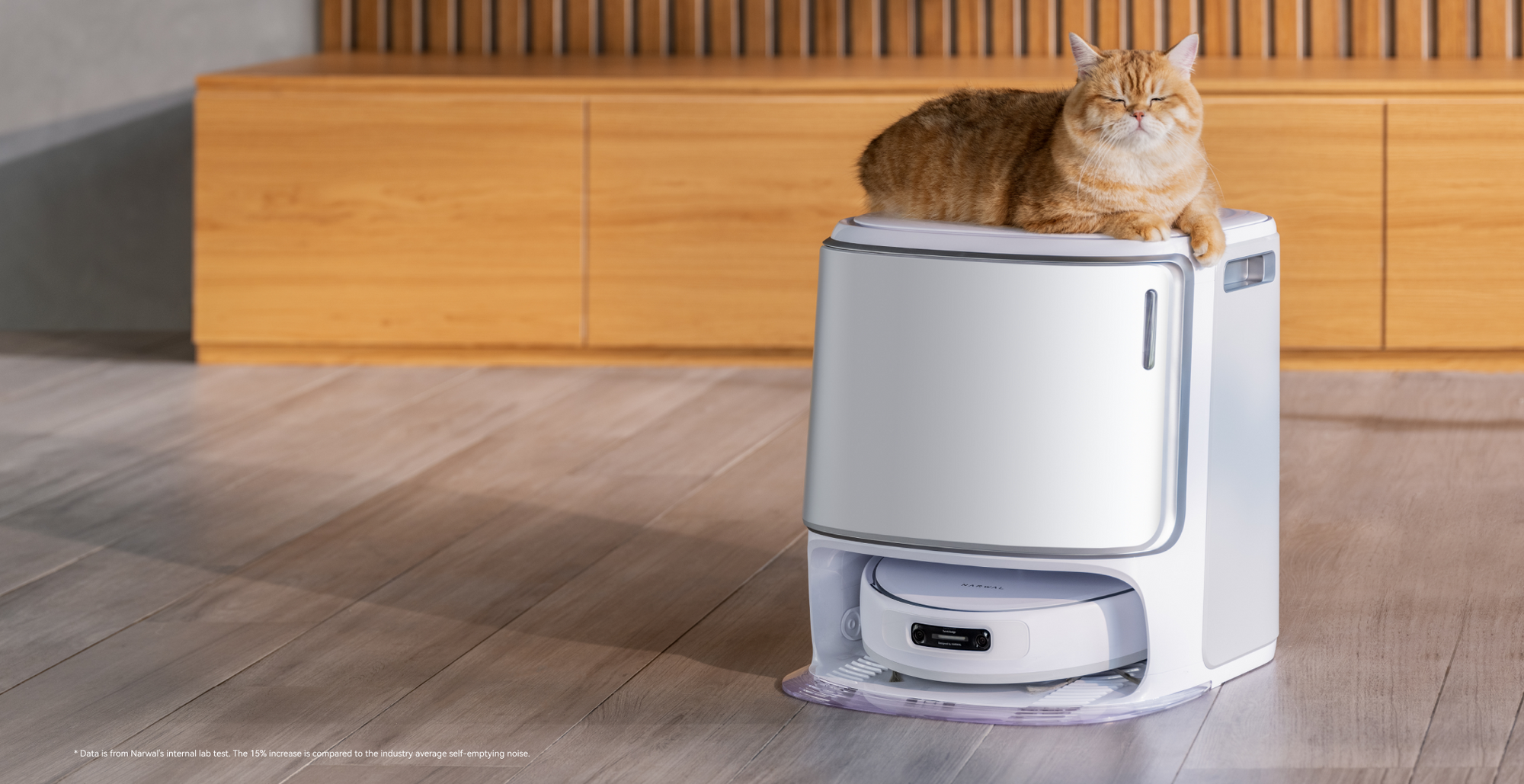 Narwal robot vacuum base station with a cat resting on top.