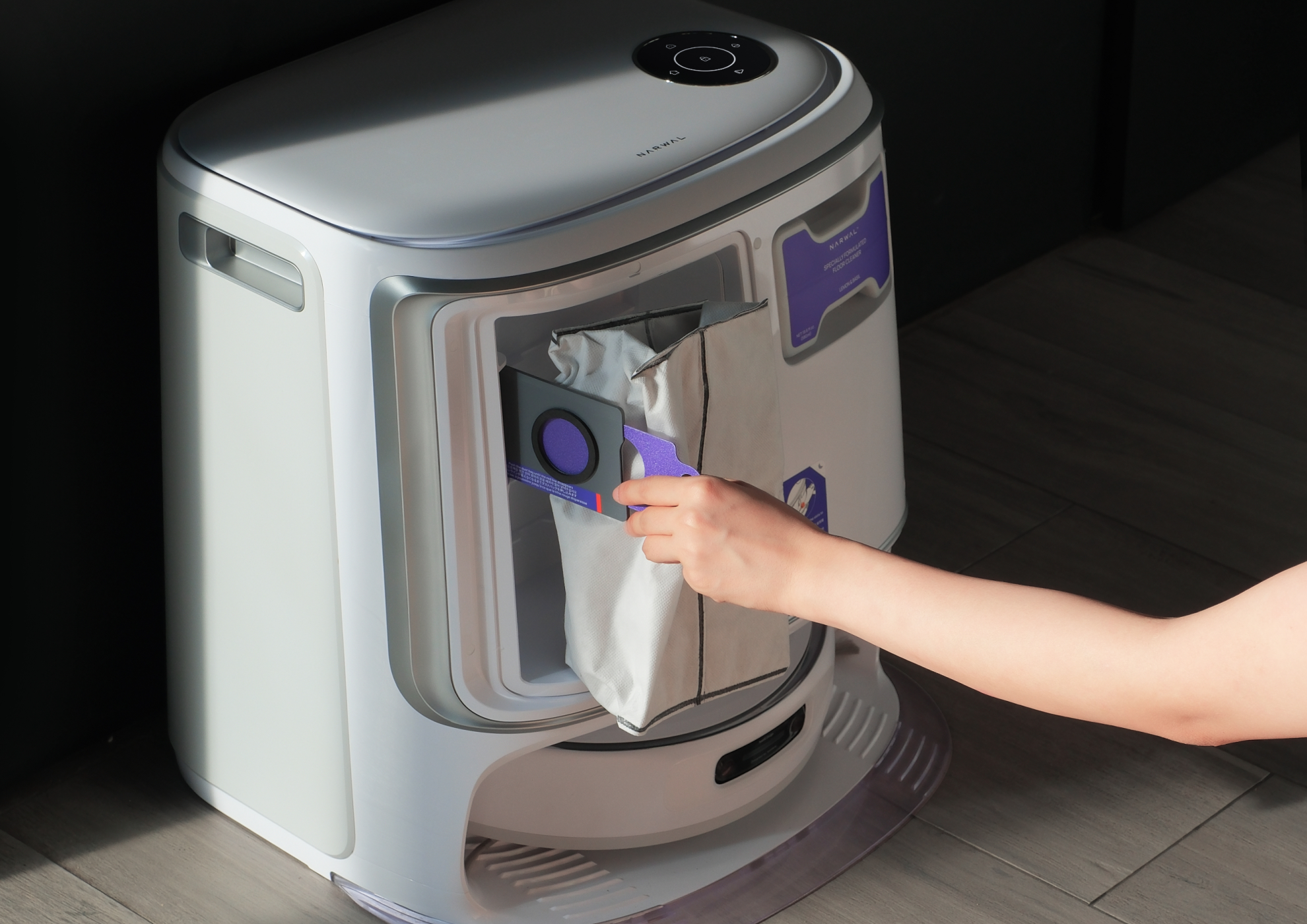 The persom is using the narwal freo z ultra robot vacuum and mop.