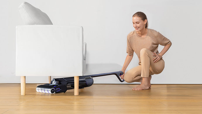 Person using the Narwal S20 Pro cordless vacuum mop to clean under a couch, demonstrating its ease of maneuverability.